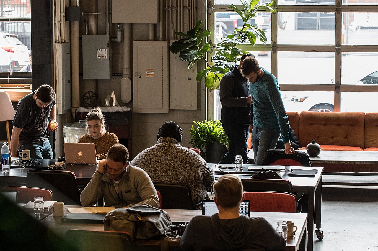 Colleagues working at shared tables in an open space